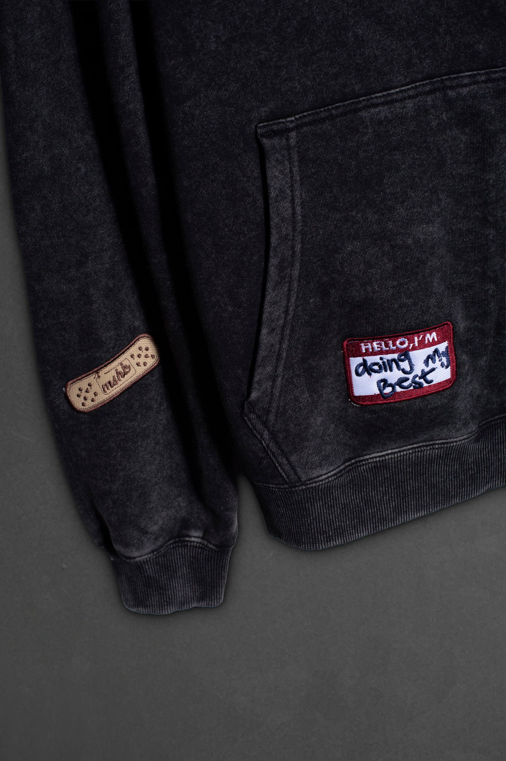 Detalle del bordado curita en hoodie negro washed Boca