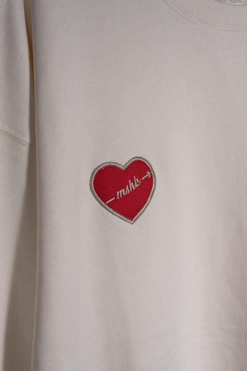 Detalle del bordado trébol en buzo vainilla Lucky Heart