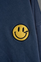 Detalle del bordado rayo en la manga del buzo azul washed Happy Storm
