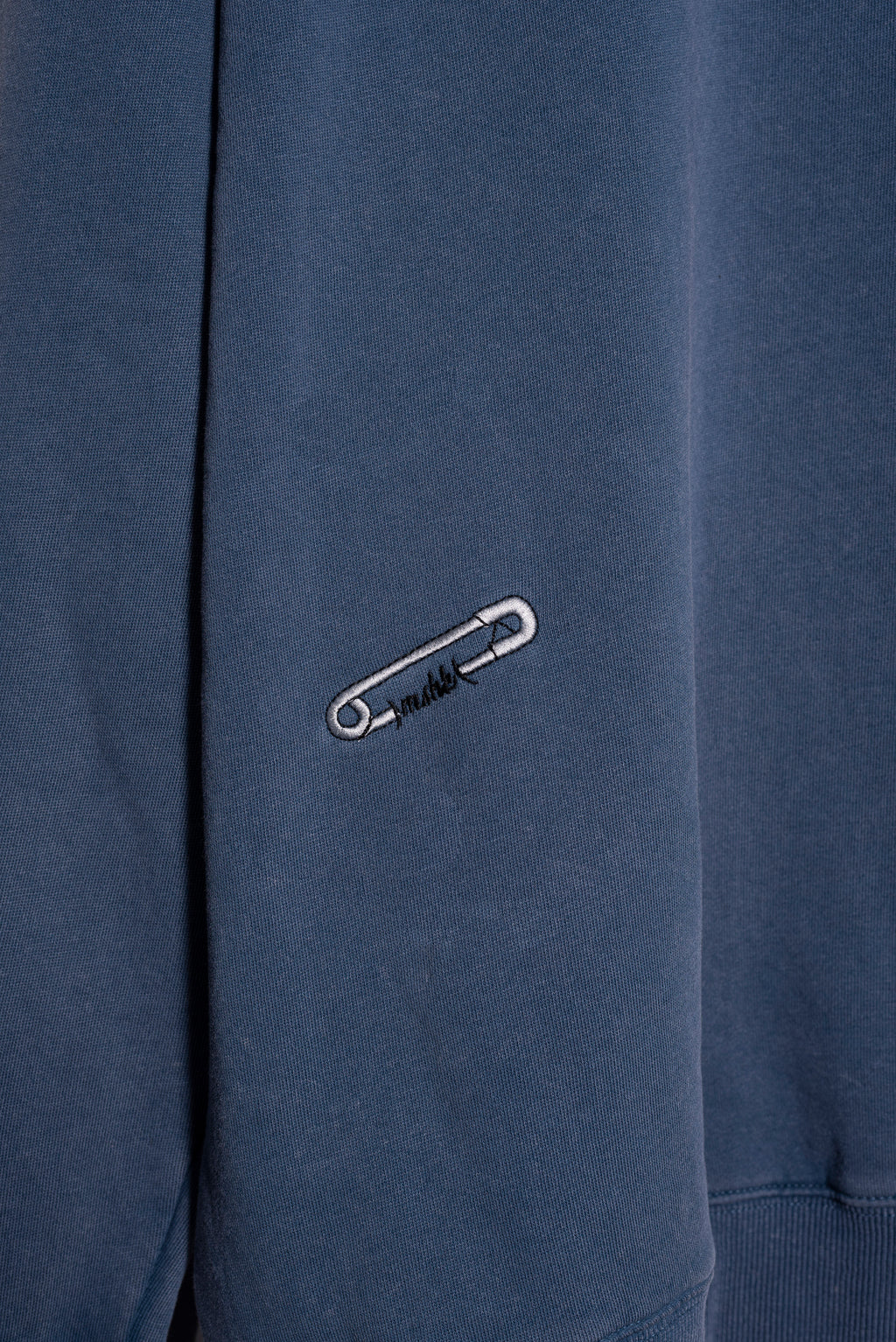 Modelo con buzo azul washed oversize Varsity M de Mushkana