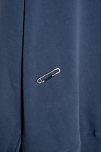 Modelo con buzo azul washed oversize Varsity M de Mushkana
