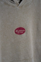 Detalle del bordado Mushkana en el pecho del hoodie khaki washed